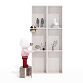White Bookcase With Decorative Small Figurines Plant And Candle Holder Near Doll Holding Gold Balloon