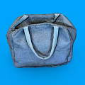 Gray Canvas Bag with Front Pocket and Round Badge on Blue Background