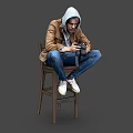 A Man Sitting On Wooden Chair Holding Camera Wearing Brown Jacket Gray Hoodie Blue Jeans