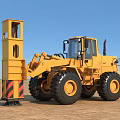Yellow Utility Vehicle With Large Tires And Front Boom In Open Field Under Blue Sky