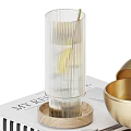 Decorative Ornament Set With Transparent Glass Cup Wooden Base And Golden Bowls On Magazine