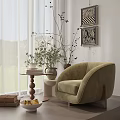 Modern Light Green Armchair with Small Round Table Books Vase Wall Art and Curtains in Cozy Setting