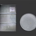 Silver Metal Drums Standing And Tilted With Label On Reflective Surface