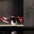 Modern Red And White Flowing Sculpture With Dark Striped Wall Green Plants And Water Reflection