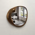 Irregular Shaped Brown Mirror Reflecting Modern Living Room With Sofa And Pillows