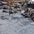 Damaged Building Interior With Collapsed Structures Broken Red Walls Debris And Wooden Fragments