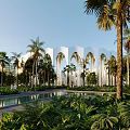 Tropical Landscape with White Arched Building Palm Trees Pool and Lush Greenery