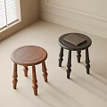 Two Round Brown And Black Wooden Stools In Light Room Corner With Book On Top