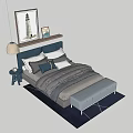 Modern Double Bed with Gray Headboard Pillows Striped Quilt Footstool Nightstand Lamp Wall Art