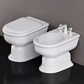 White Ceramic Toilet and Bidet with Chrome Faucets on Black Floor and Gray Wall