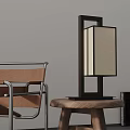 Modern Table Lamp with Black Frame and Beige Shade on Wooden Stool Beside Leather Chair