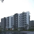 Modern Mid Rise Residential Building With Landscaped Greenery Water Reflection and Pedestrian Walkway