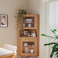 Wooden Sideboard Cabinet with Glass Doors Displaying Dishes Green Plant Framed Artwork and White Chair