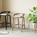 Black and Light Wood Bar Stools with Green Plant and Open Magazine on Carpet