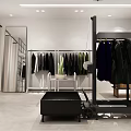 Modern Clothing Store Interior With Racks Mirrors Display Tables Folded Clothes And Ceiling Lights