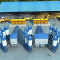 Industrial Factory Featuring Blue Roof Yellow Equipment Orange Construction Vehicles And White Blue Storage Silos