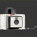 Vintage Digital Camera Featuring White Body Black Lens And Leather Strap
