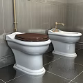 Toilet With Brown Seat Bidet Gray Tiled Walls Dark Flooring And Gold Fixtures