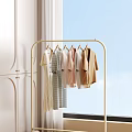 Stylish Clothes Hanging On Golden Rack With Bright Window And White Cabinet