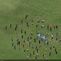 Group of People Standing in Arranged Formation on Green Grass Field