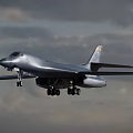 Silver Fighter Jet Flying With Extended Landing Gear In Cloudy Sky