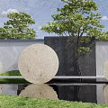Circular Stone Landscape Sculptures in Garden with Water Feature Grass Trees and Gray Black Wall