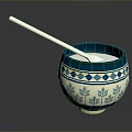 Carved Sculpture Bowl With Blue White Geometric Leaf Patterns And Silver Spoon On Smooth Surface
