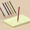 Colored Pencils With Red One Arranged Around Yellow Notepad On Light Brown Background