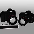 Two Canon Digital Cameras Placed On Photography Book For Gear