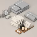 Gray and Beige Towels Folded and Rolled with Bath Products Bottles Candles Soap and Tray