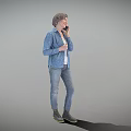 Elderly Woman In Blue Printed Jacket And Jeans Standing Against Gray Background