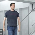 Man in Dark Blue T-Shirt and Blue Jeans Walking in Modern Building with Staircase Rail