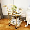 Commercial Serving Cart With Gold Frame Glass Shelves Featuring Green Plants White Tableware