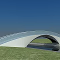 Modern Curved Bridge With Glass Railing Over Waterway And Green Grass