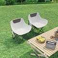 White Foldable Outdoor Chairs With Gray Accents On Lawn And Wooden Table With Fruits