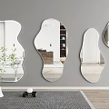 Four Irregular Shaped Mirrors Hanging On Gray Wall With Vase Plant And Wooden Floor