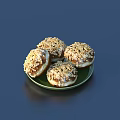 Four Delicious Nut Sprinkled Doughnuts Served on a Green Plate