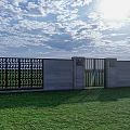 Gray Building Exterior Wall With Perforated Design And Gate On Green Lawn Under Sunny Sky