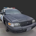 Old Dusty Black And White Police Car With Emergency Lights Parked In Parking Lot