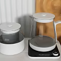 Modern Glass Electric Kettles in White and Yellow on Kitchen Countertop with Wall Decor