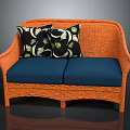 Orange Rattan Two Seater Sofa With Blue Cushions And Leaf Patterned Pillows
