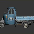 Blue Three Wheeled Cargo Truck With Open Bed And Metal Frame Cab