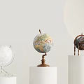 Colored And Silver Decorative Globes Displayed On White Cylindrical Pedestals With Wooden And Metal Stands