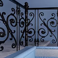 Ornate Staircase With Black Iron Railings Blue Wall Green Plant Black Vases And Pebble Decor