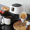 White Air Fryer Kitchen Appliance Featuring Digital Display And Cooking Fries