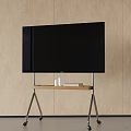 Black TV on Metal Stand with Wooden Top and Wheels Against Light Wooden Wall