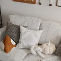 Cozy Textured Pillows On White Sofa With Orange Accent And Decorative Pumpkin