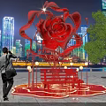 Giant Red Rose Sculpture Illuminated At Night With City Skyline And People Around