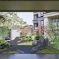 Courtyard Garden with Lush Green Plants Rocks and Trees in Building Background
