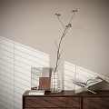 Fresh Aquatic Plant Sprig in Transparent Vase with Books and Blinds Shadow on Light Wall